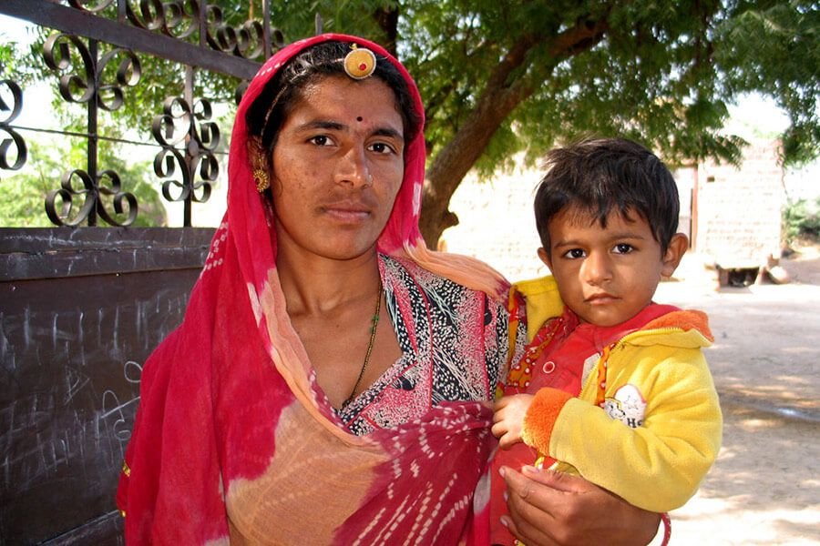 Village families Bishnoi mother holding her young son in the village, Jodhpur