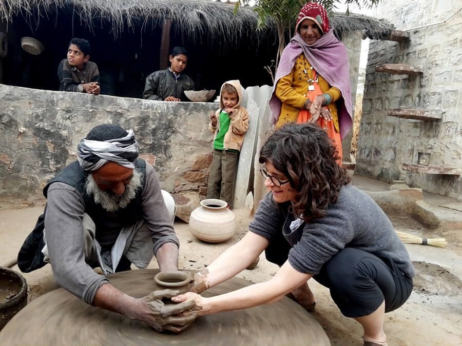 Trying the potter's wheel Village potter teaching a visitor at the potter's wheel near Jodhpur