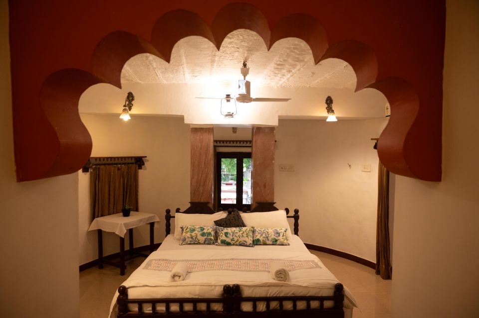 Garden Room bedroom with carved Rajasthani arch and double bed at The Mandore, Jodhpur