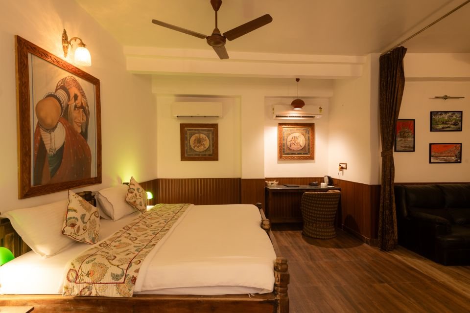 Bedroom with lounge area Mandore Jacuzzi room with king bed, wooden floor and lounge area at The Mandore, Jodhpur