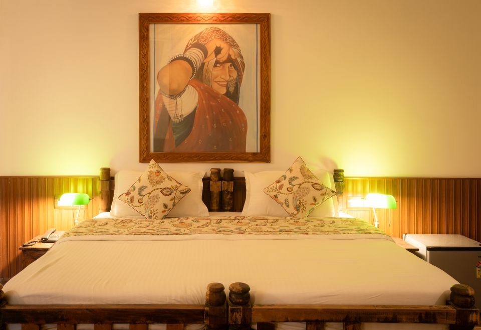 King bed with Rajasthani portrait Mandore Jacuzzi king bed with Rajasthani portrait and green reading lamps, Jodhpur